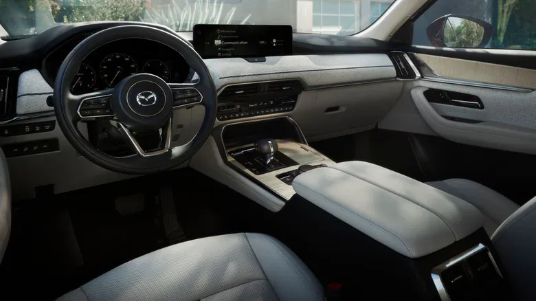 The interior of a Mazda CX-90 with light-colored fabric and leather